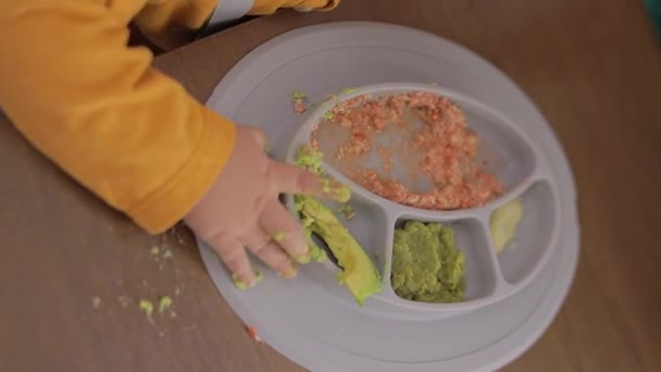 小孩手拿着食物在盘子里吃早餐时的特写 — 图库视频影像