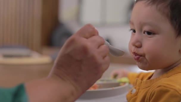 숟가락 먹이를 받고있는 아이의 얼굴의 클로즈업 — 비디오