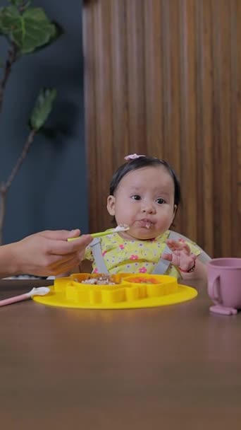 엄마는 아기를 도입하여 보완적인 먹이를 식탁에서 음식을 제공합니다 아기는 개념을 — 비디오