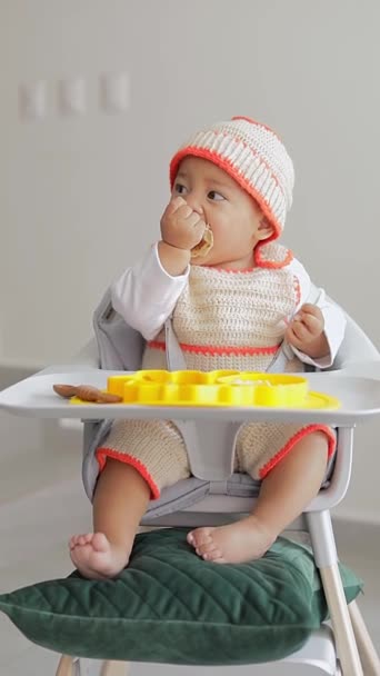 손으로 팬케이크를 자신의 의자에 앉아있는 아기의 아기는 개념을 — 비디오
