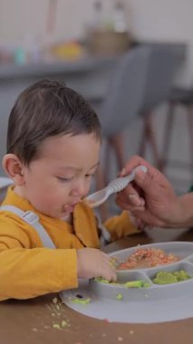Kaşıkla beslenen bir bebeğin yüzünün yakın plan görüntüsü. Bebekler için tamamlayıcı beslenme