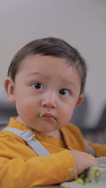 손으로 처음으로 음식을 먹고있는 아기의 얼굴을 닫습니다 아기는 개념을 — 비디오