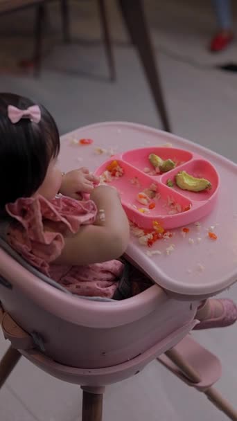 青い皿から椅子に座って食べている女の子のトップビュー 赤ちゃんのための補充給 — ストック動画