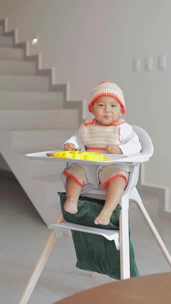 Dítě Dělá Gesta Při Jídle Zatímco Sedí Křesle Obývacím Pokoji — Stock video