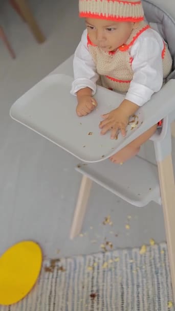 의자에 앉아있는 바닥에 자신의 음식을 던지는 소년의 — 비디오
