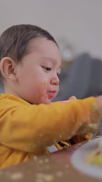 婴儿在家里吃早餐的时候 用手吃东西 咬着杯子 婴儿的补充喂养 — 图库视频影像