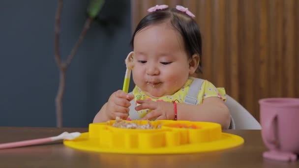 婴儿坐在家里的桌子旁 用勺子吃饭 — 图库视频影像