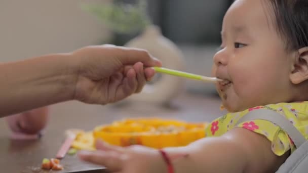 Bebé Vuelve Hacia Cámara Mientras Alimenta Con Cuchara — Vídeos de Stock