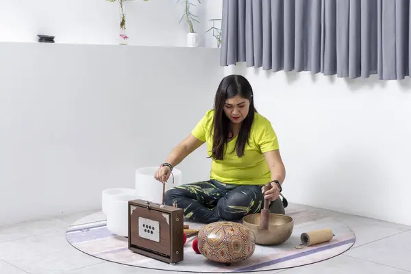 Meditation with Tibetan bowls. Woman in a yoga studio playing Tibetan bowls.