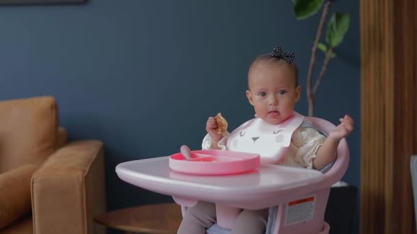 一个可爱的墨西哥姑娘坐在椅子上 用手吃饭 婴儿补充营养餐 — 图库视频影像