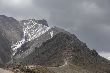 Bir grup insan Meksika 'daki Nevado de Toluca dağına tırmanarak uzaklarda yürüyor.