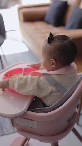 아기는 의자에 앉아있는 접시에서 음식을 — 비디오