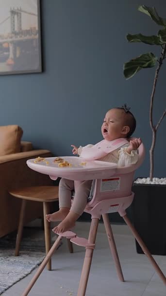아기는 집에서 식사를하는 그녀의 의자에 울고있다 — 비디오