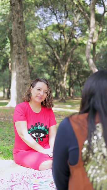笑顔の女性は 屋外公園でセッション中に選択したタロットカードを見ます — ストック動画