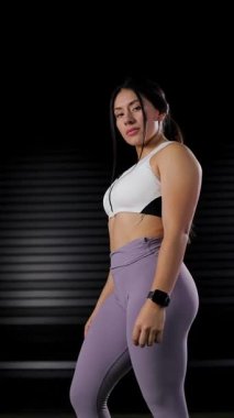 Spor giyimli kadın sporcu akıllı saatine bakıyor. Spor reklamcılığı konsepti