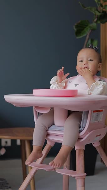 Menina Comendo Sua Primeira Comida Com Mãos Sentado Sua Cadeira — Vídeo de Stock