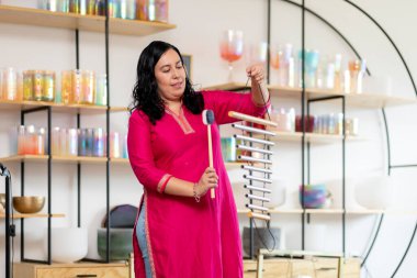 Bir müzik stüdyosunda çan çalan Meksikalı müzisyen Tibet müzik kaseleri, pervane, flüt ve gong çalıyor.