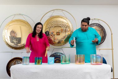 İki profesyonel müzisyen ses iyileştirme oturumu sırasında kristal kaseler ve ziller çalıyorlar ya da stüdyolarında ses banyosu yapıyorlar.