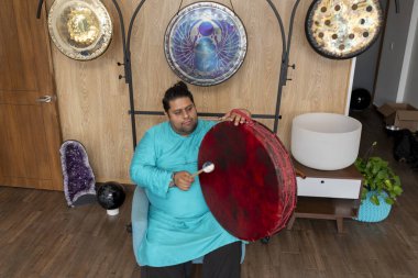 Şamanik davul çalan Meksikalı müzisyen bir müzik stüdyosunda ses iyileştirme terapisi sırasında.
