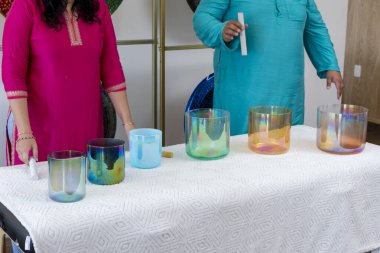 İki müzik terapisti müzik stüdyosunda ses iyileştirme seansı için kristal kaseler hazırlıyorlar.