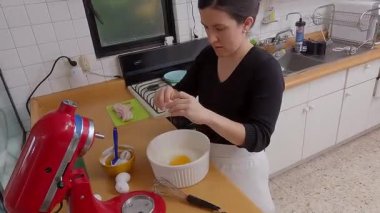 Becerikli ev yemekleri, taze yumurtaları seramik karıştırma kabına kırma, geleneksel kiş hazırlama, parlak mutfak ortamında profesyonel mutfak hassasiyeti.