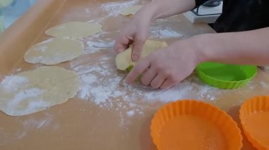 Profesyonel pasta şefi, rengarenk silikon kalıplara taze hamur sıkıştırarak, unlu mutfak yüzeyinde ustalıkla geleneksel ev yapımı pişirilmiş ürünleri hazırlıyor.