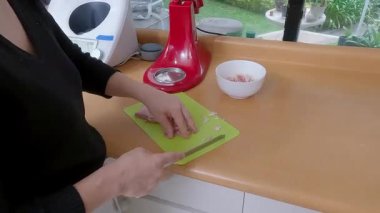 Profesyonel şef ahşap kesme tahtasında jambon doğruyor, güneş ışığında ev yapımı kiş için düzenli olarak taze malzemeler hazırlıyor.