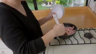 Profesyonel şef tavada domuz pastırması şeritleri pişiriyor, iyi donanımlı mutfak uzmanlığıyla lezzetli kiş malzemelerini hazırlıyor.