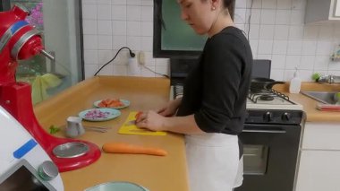 Ev yapımı havuç doğrama, ahşap kesim tahtasında soğan doğrama, ev yapımı mantı için taze malzemeler hazırlama.