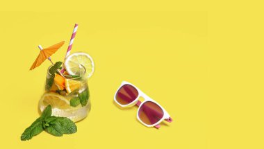 Sarı arka planda taze malzemelerden yapılan yaz kokteyli. Yaz konsepti