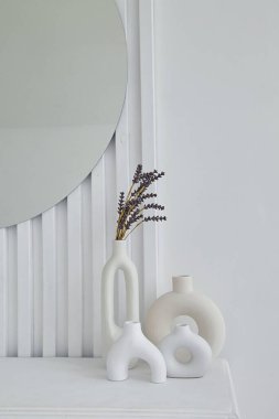 Beyaz vazolar beyaz bir duvarın arkasında. Vazoda lavanta