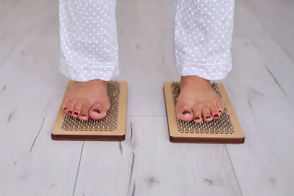 Sadhu 'nun ayakları tahtada duruyor. Çivilerin üzerinde duruyor