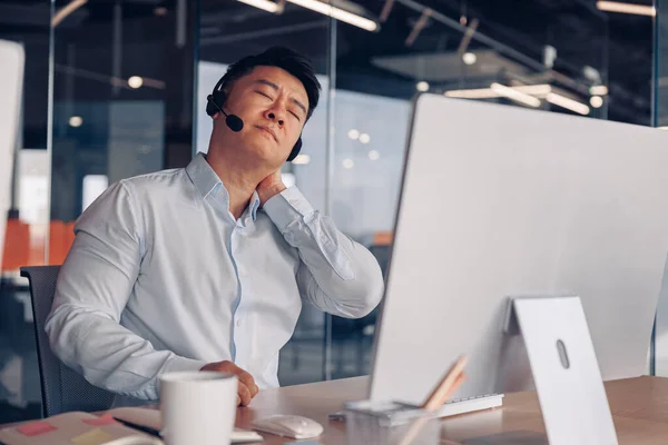 stock image Tired businessman in headphones working on computer while sitting in office. Business concept