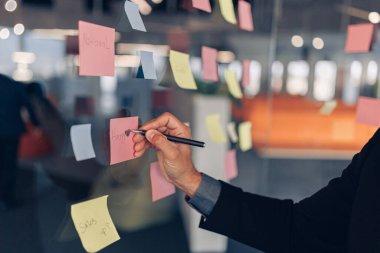 İş kadını elleri ofisteki motivasyon kuruluna yapışkan notlar yazıyor. Yüksek kalite fotoğraf