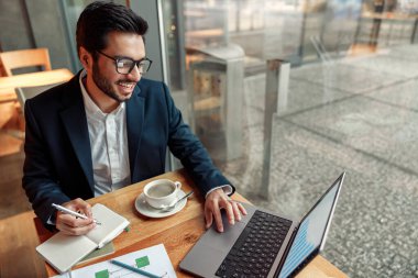 Hintli işadamı, kafede çalışırken not defterine not alıyor. Yüksek kalite fotoğraf