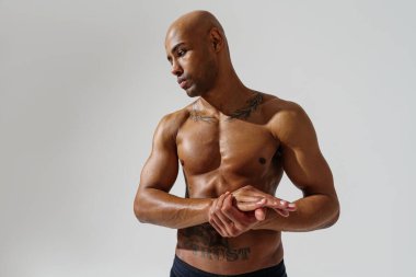 Attractive sporty man with muscled naked body on white studio background. High quality photo