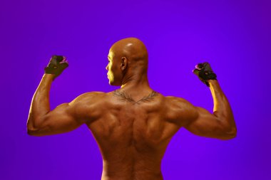 Stüdyo arka planında renk filtresi olan çıplak erkek gövdesi. Kuvvet ve motivasyon