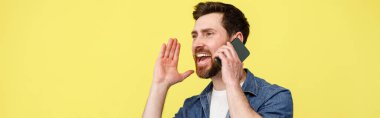 Telefonda konuşurken ve elleriyle el kol hareketi yaparken yüksek sesle bağıran mutlu adam. Stüdyo çekimi
