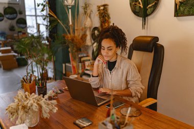 Female decorator working online from own art studio and check customers order . High quality photo