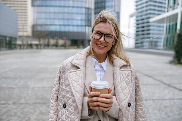 stock image Businesswoman holding coffee while standing on business center background. High quality photo