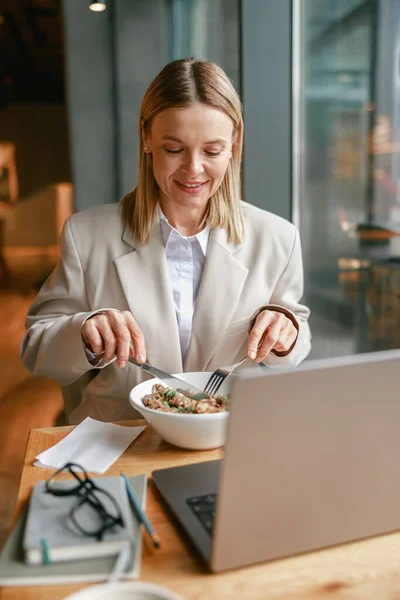 Businesswoman is having a business lunch and working on laptop in cafe. High quality photo