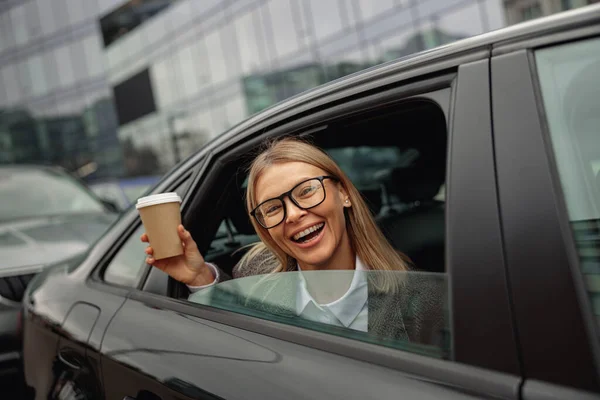 Uśmiechnięta Kobieta Pasażer Pije Kawę Wynos Patrząc Przez Okno Taksówki — Zdjęcie stockowe