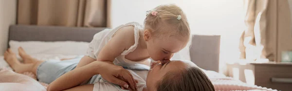 Young Mother Smiling Kiss Her Baby While Lying Bed Home — Stock Photo, Image