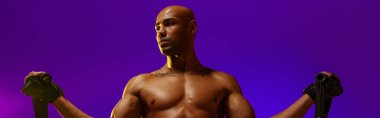 Man performs exercises with expander on studio background with color filter. Strength and motivation