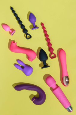 Different adult sex toys such as dildo, vibrator, buttplug on yellow background. High quality photo