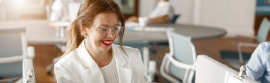 Smiling businesswoman work with documents sitting in office. Blurred background