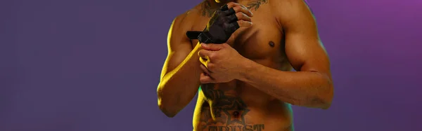 Мускулистый Человек Надевает Боевые Перчатки Позируя Фоне Студии Цветным Фильтром — стоковое фото
