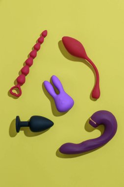 Different adult sex toys such as dildo, vibrator, buttplug on yellow background. High quality photo