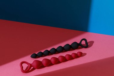 Anal plugs or dildo on pink background with shadows. Sex toys for anal play. High quality photo
