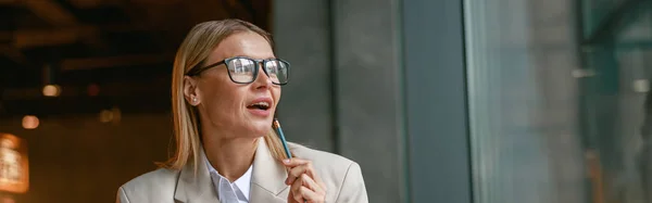 stock image Woman in glasses working on laptop while sitting in cafe near window. Distance work